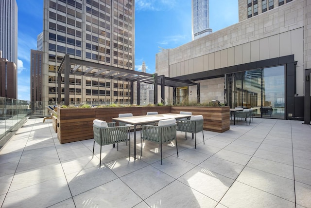 view of patio with a view of city, outdoor dining area, and a pergola