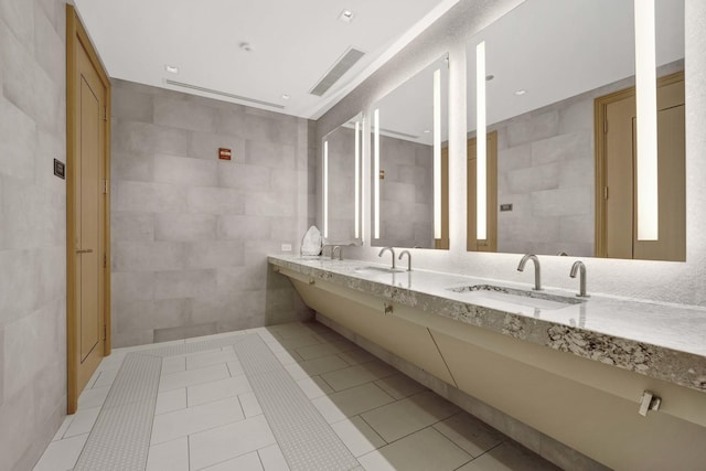 bathroom featuring a sink, tile walls, and tile patterned flooring