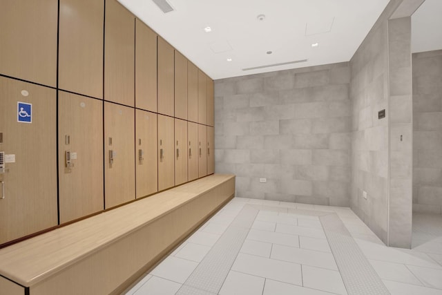 bathroom featuring tile patterned flooring, tile walls, and visible vents