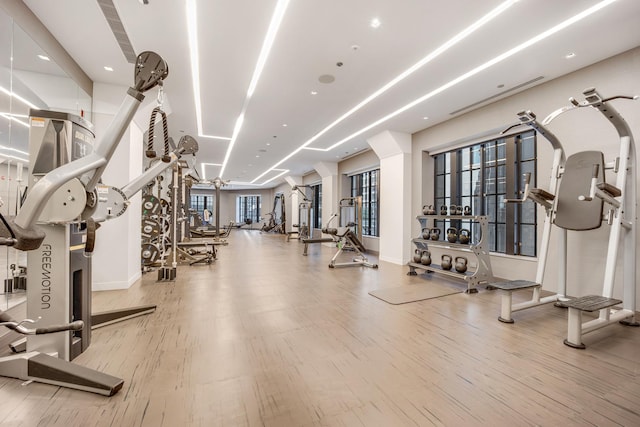 exercise room with baseboards and wood finished floors