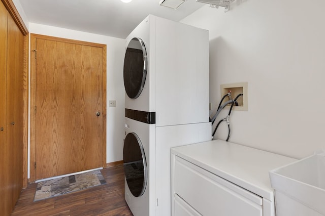 clothes washing area with a sink, dark wood-type flooring, and stacked washer / dryer