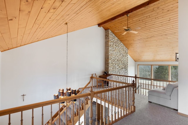 interior space with a chandelier, beamed ceiling, an upstairs landing, carpet flooring, and wooden ceiling