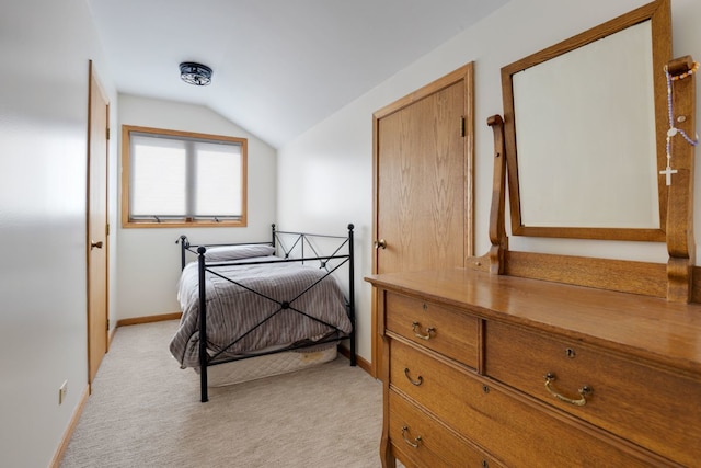 bedroom featuring light carpet, baseboards, and lofted ceiling