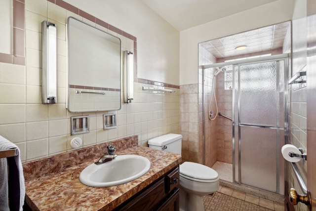 full bath with tile patterned floors, toilet, tile walls, and a stall shower