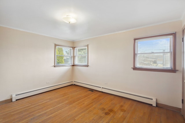 empty room featuring crown molding, wood finished floors, and baseboards