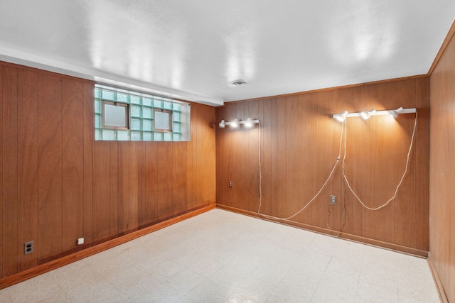 unfurnished room featuring tile patterned floors and wood walls