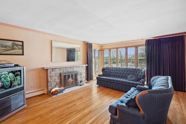 living room featuring baseboard heating, a fireplace, and wood finished floors