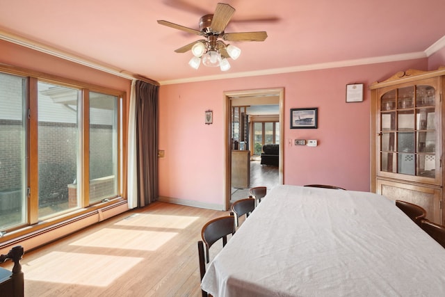 bedroom featuring ceiling fan, baseboards, light wood-type flooring, ornamental molding, and baseboard heating