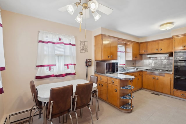 kitchen with stainless steel gas cooktop, under cabinet range hood, dobule oven black, brown cabinets, and backsplash