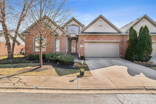 traditional home with a garage, brick siding, concrete driveway, and stucco siding