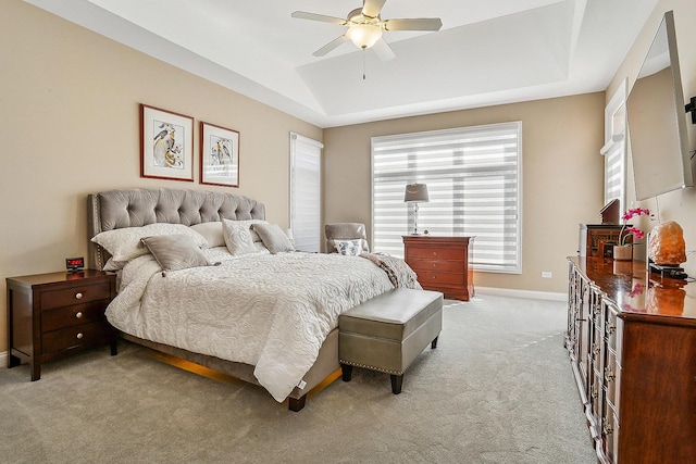 bedroom with vaulted ceiling, multiple windows, baseboards, and light carpet