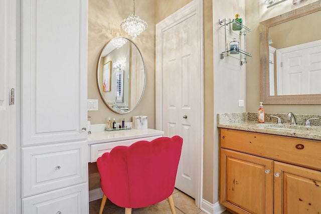 bathroom with a notable chandelier, vanity, and tile patterned flooring