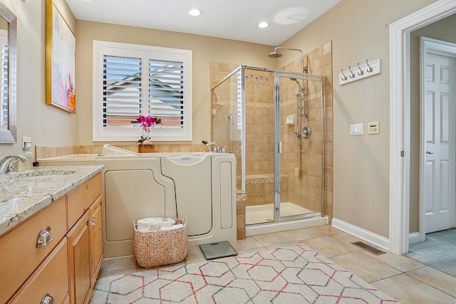 bathroom with tile patterned flooring, visible vents, a stall shower, a bath, and vanity