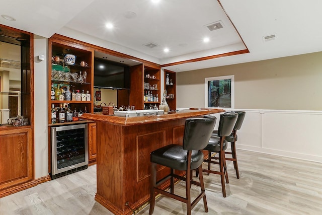 bar featuring visible vents, wet bar, beverage cooler, and light wood finished floors