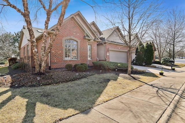 view of front facade featuring an attached garage, brick siding, and driveway