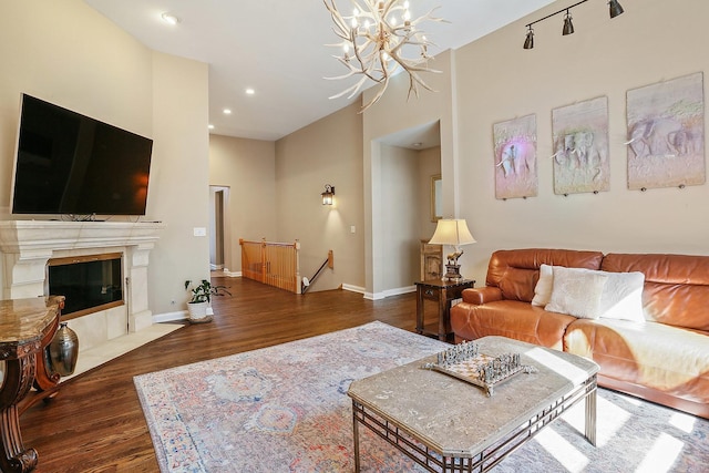 living area with recessed lighting, baseboards, an inviting chandelier, and wood finished floors