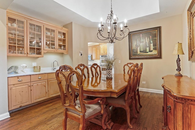 dining space with baseboards, an inviting chandelier, and dark wood-style flooring