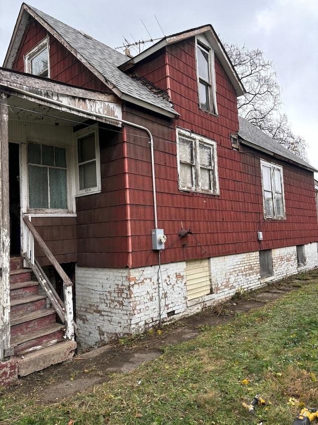 view of property exterior featuring roof with shingles and entry steps