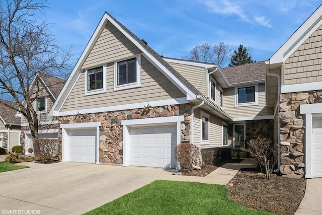 view of front of home featuring concrete driveway, a garage, stone siding, and a shingled roof