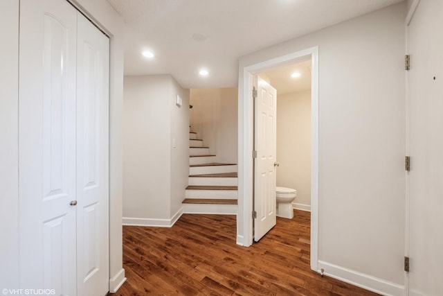 hall featuring recessed lighting, baseboards, wood finished floors, and stairs