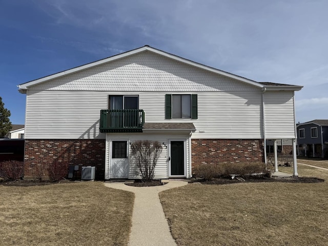 back of house featuring a yard, cooling unit, and brick siding