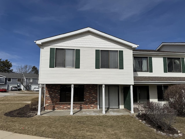 view of front of property featuring brick siding and a front yard