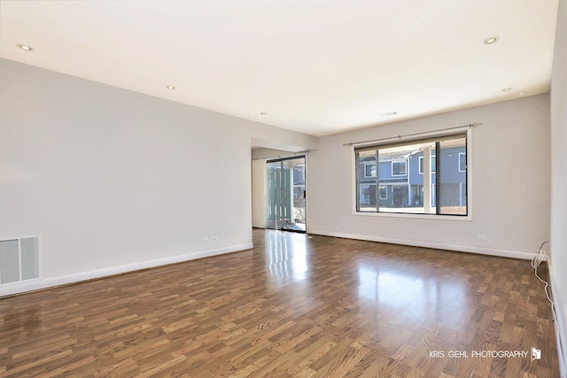 spare room with visible vents, recessed lighting, baseboards, and wood finished floors