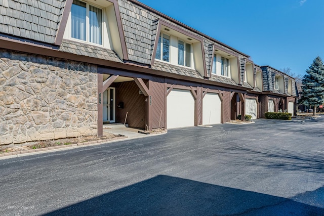 view of property featuring aphalt driveway and an attached garage