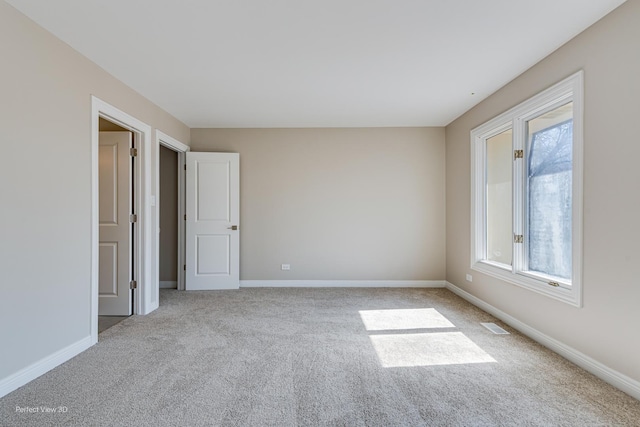 empty room featuring baseboards, carpet floors, and visible vents