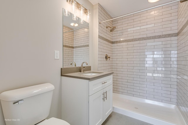 full bath with a tile shower, tile patterned floors, toilet, and vanity