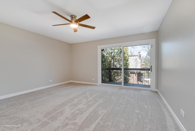 carpeted spare room featuring baseboards and a ceiling fan