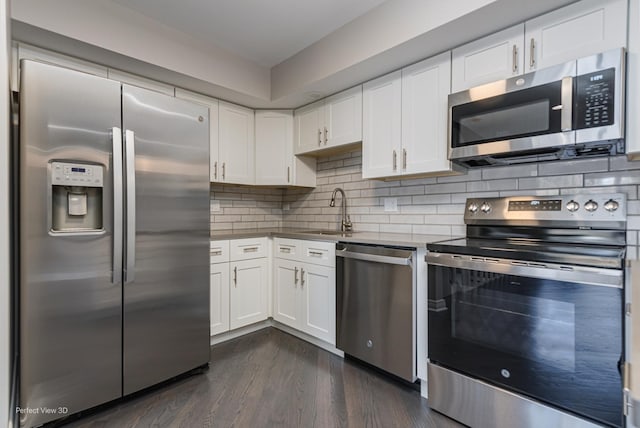 kitchen featuring dark wood finished floors, a sink, white cabinets, appliances with stainless steel finishes, and tasteful backsplash