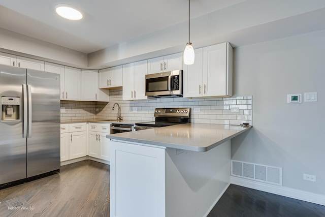 kitchen featuring a sink, stainless steel appliances, dark wood-type flooring, and visible vents