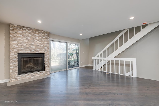 unfurnished living room with recessed lighting, a large fireplace, and wood finished floors