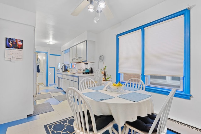 dining space featuring light tile patterned flooring, ceiling fan, and a baseboard radiator