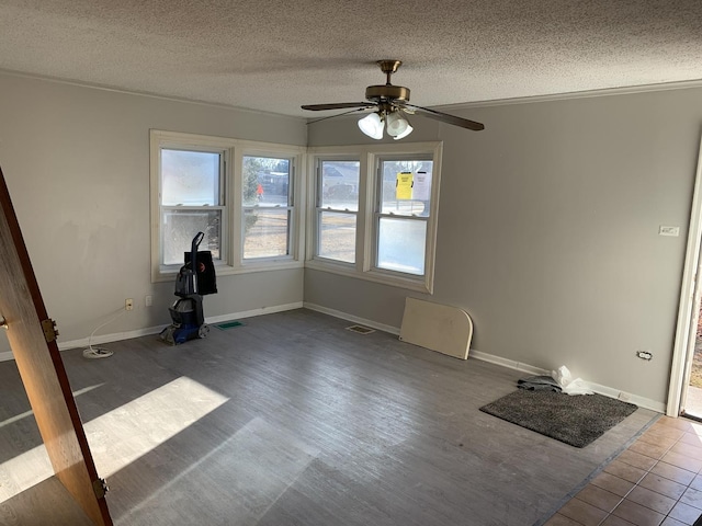 unfurnished room with visible vents, a textured ceiling, baseboards, and wood finished floors