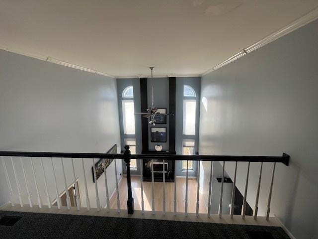 staircase with visible vents, wood finished floors, and crown molding