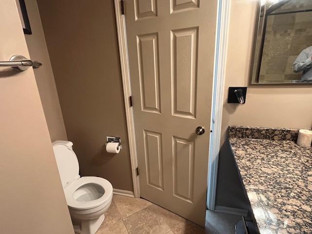 bathroom featuring baseboards and toilet