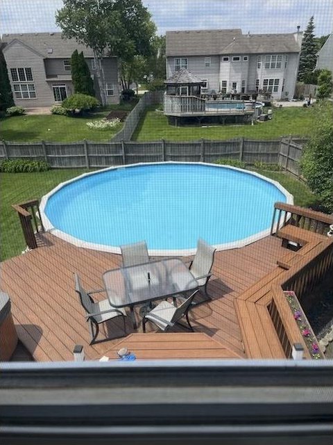 view of swimming pool featuring a fenced in pool, a wooden deck, and a fenced backyard