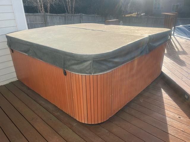 deck with fence and a hot tub