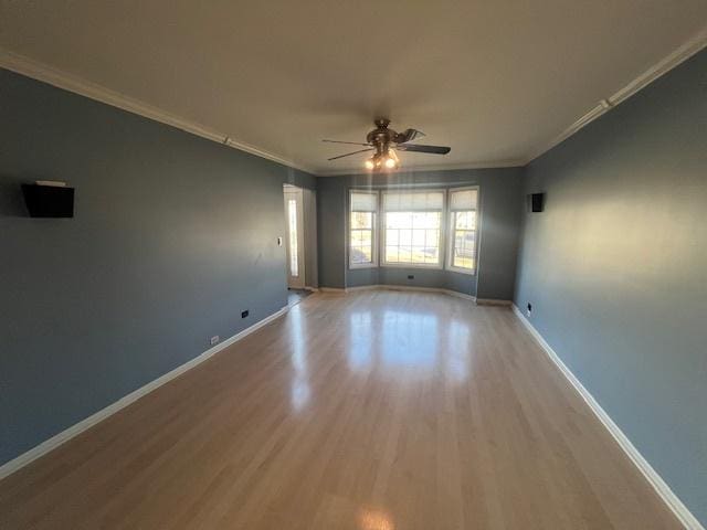 spare room with crown molding, wood finished floors, and ceiling fan