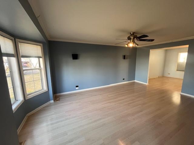 unfurnished room with baseboards, crown molding, a ceiling fan, and wood finished floors