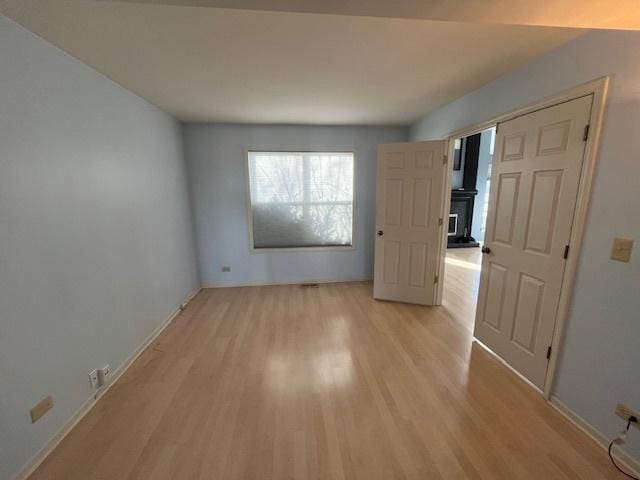 unfurnished bedroom with baseboards and light wood-style flooring