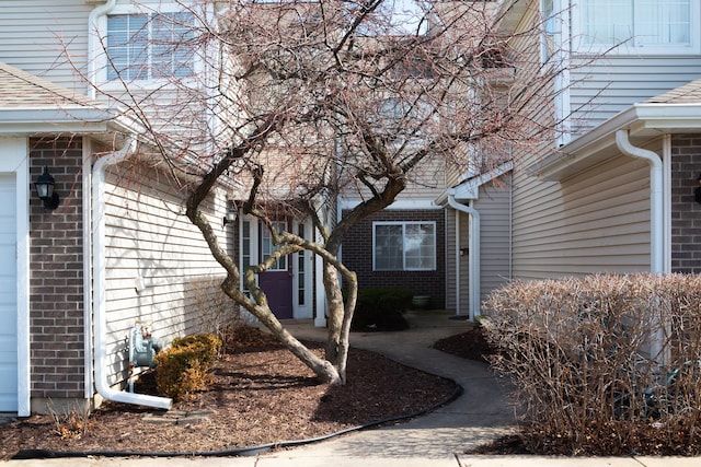 doorway to property featuring brick siding