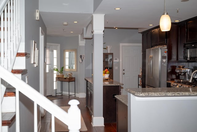 kitchen with freestanding refrigerator, recessed lighting, black microwave, range, and light stone countertops