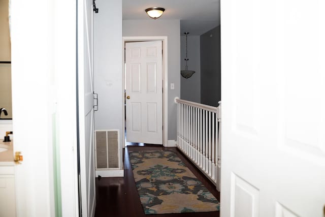 hallway featuring dark wood finished floors and visible vents