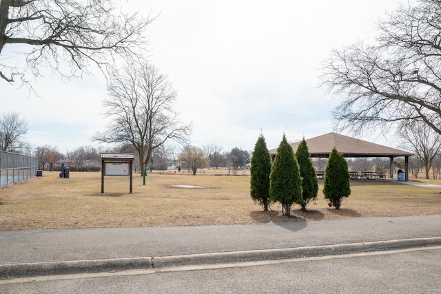 view of property's community featuring a gazebo, a lawn, and fence