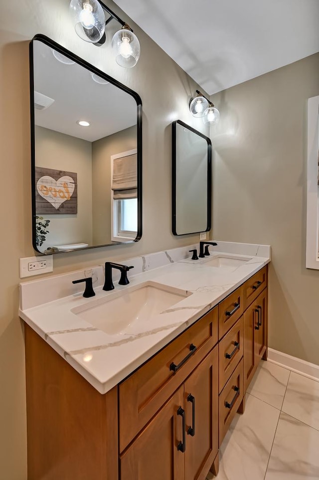 bathroom featuring a sink, baseboards, and double vanity