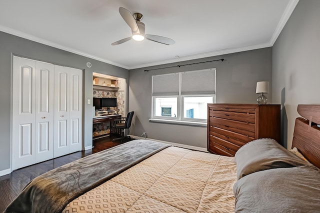 bedroom featuring a closet, baseboards, wood finished floors, and crown molding