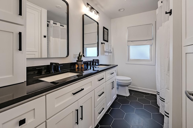 bathroom featuring a sink, toilet, double vanity, and tile patterned flooring